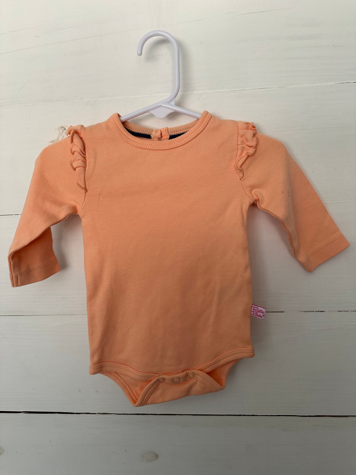 Ruffle Butts coral onesie with ruffle details