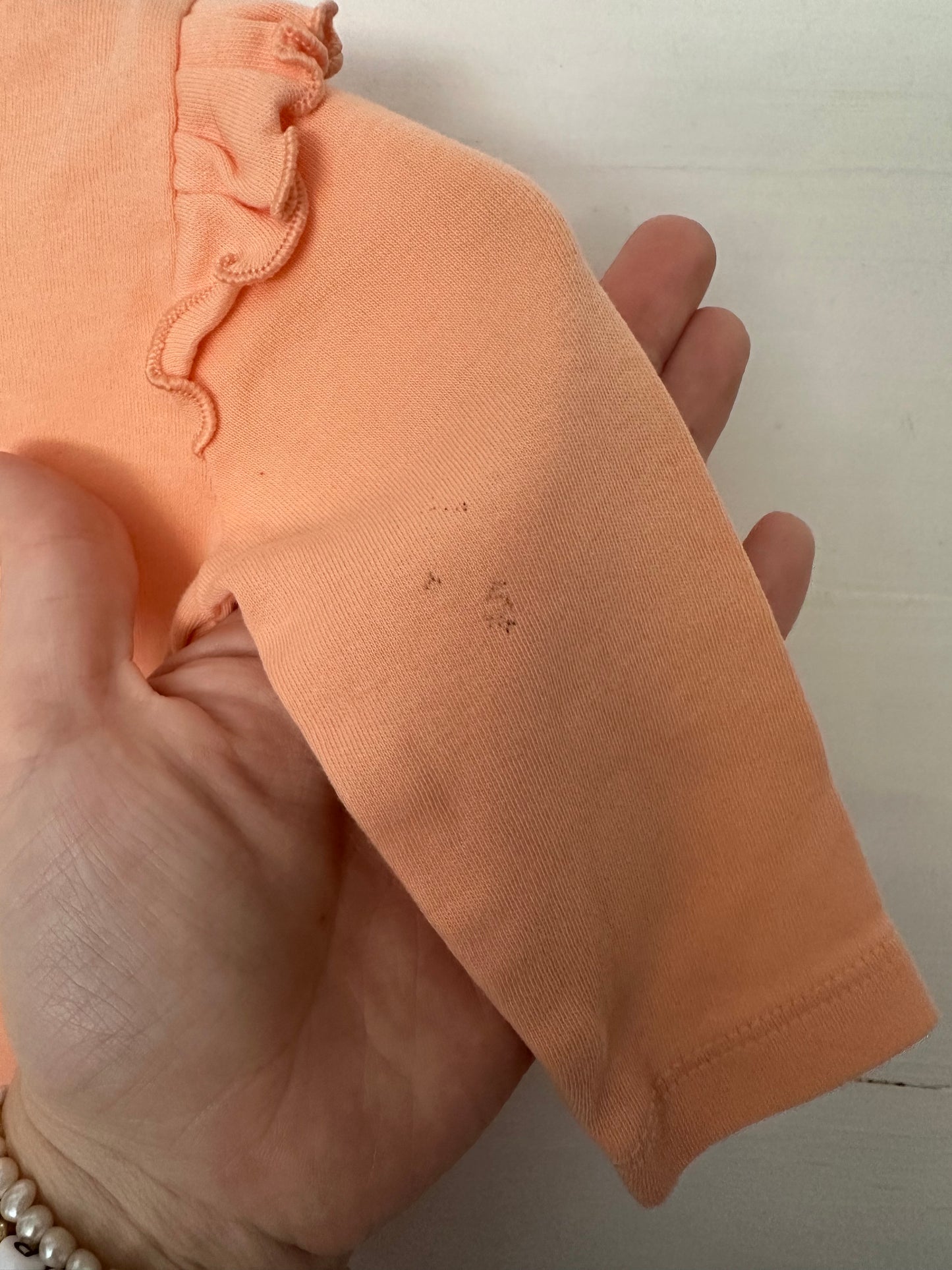 Ruffle Butts coral onesie with ruffle details